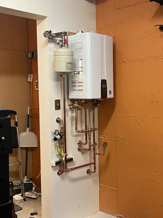 Plumbing technician inspecting water heater connections in Belgrade